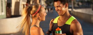 Man and woman chatting while taking a break from exercising outdoors.