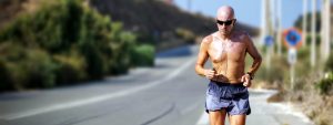 Man jogging down a long road while listening to music.