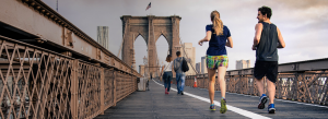 Couple running for exercise across a scenic bridge